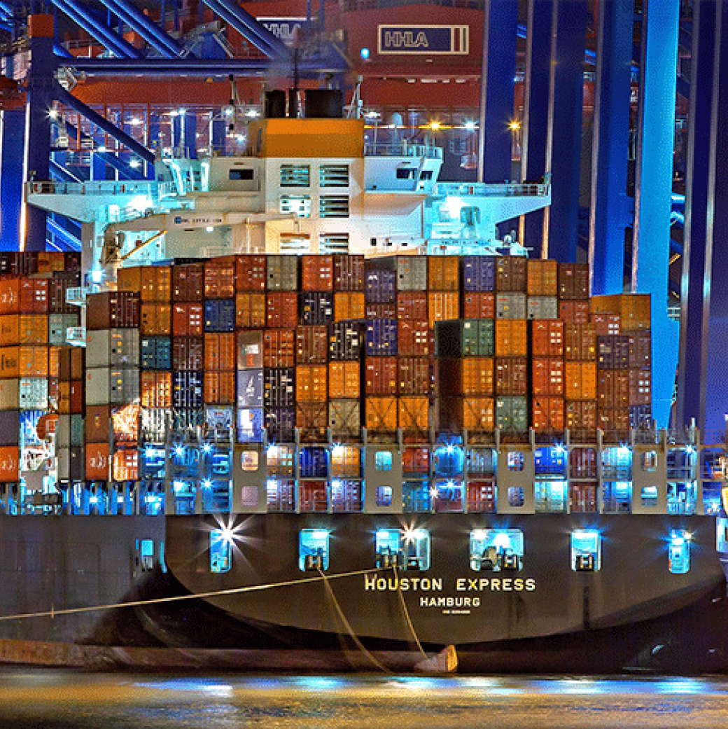 A massive ship carrying numerous containers, sailing across the vast ocean.